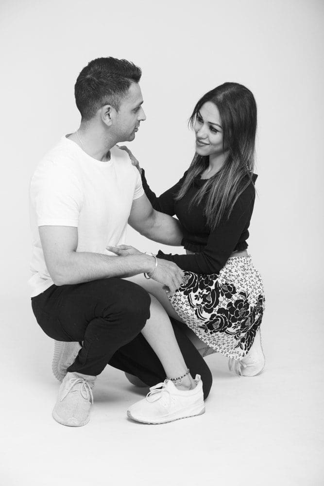 Couple holding hands and smiling during a professional Birmingham couple photoshoot by an experienced photographer.