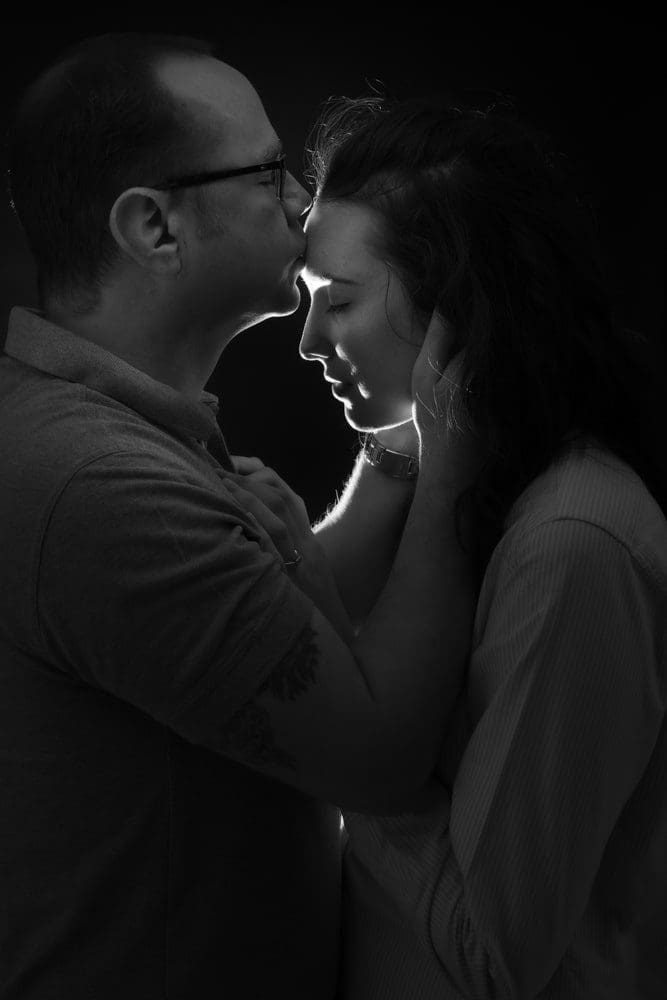 Couple smiling and posing together in a relaxed studio setting during a professional Birmingham couple photoshoot by an expert photographer.