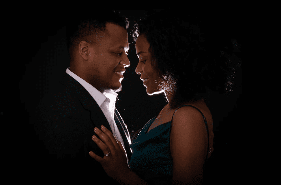 Couple posing together with gentle smiles in a studio portrait during a professional Birmingham couple photoshoot by an experienced photographer.