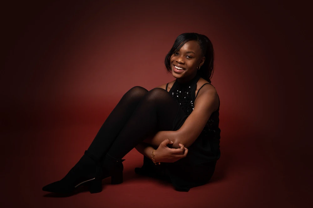 Teenage girl sitting and smiling during a studio birthday photoshoot for children and teens in Birmingham.