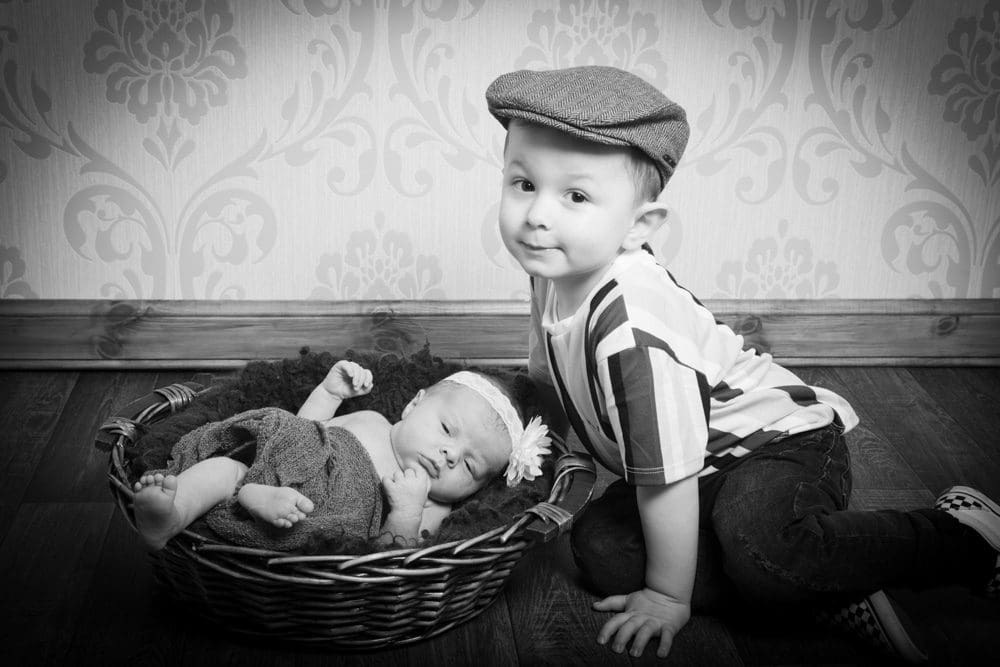 black and white newborn baby with older sibling during Birmingham photography studio session