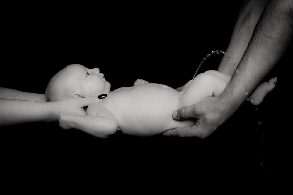 black and white newborn baby portrait in Birmingham photography studio held gently by parent hands