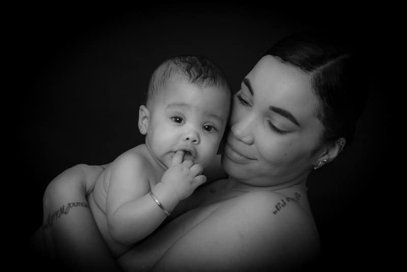 Black and white portrait of a mother holding her baby during a professional baby photoshoot in Birmingham.
