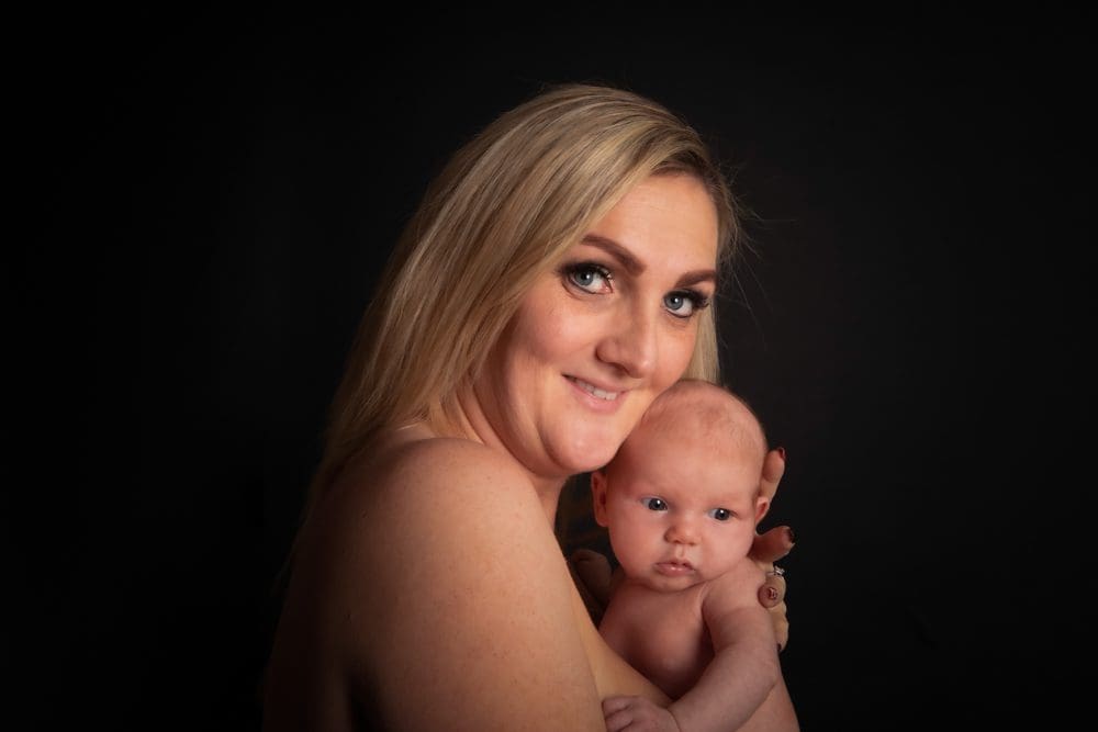 newborn baby skin to skin with mother during Birmingham newborn photography studio session