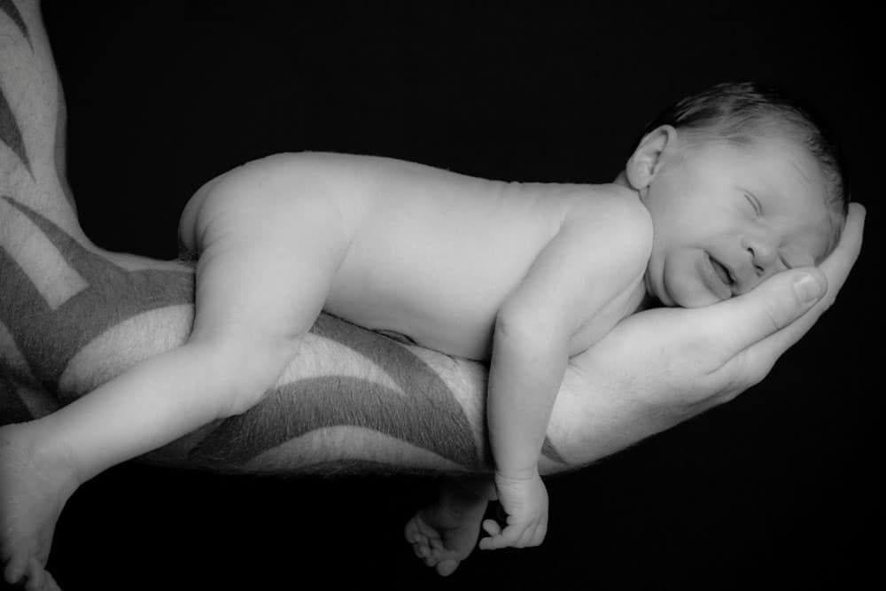 Newborn baby resting on fathers chest skin to skin Birmingham