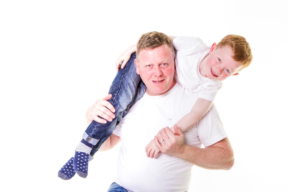 Father carrying his young son on his shoulders during a fun family photoshoot in Birmingham
