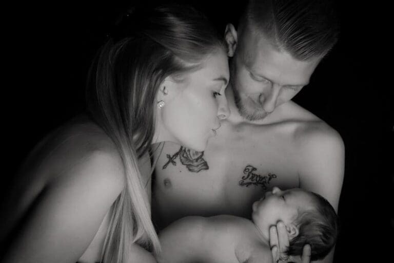newborn baby skin to skin with parents during Birmingham photography studio family portrait
