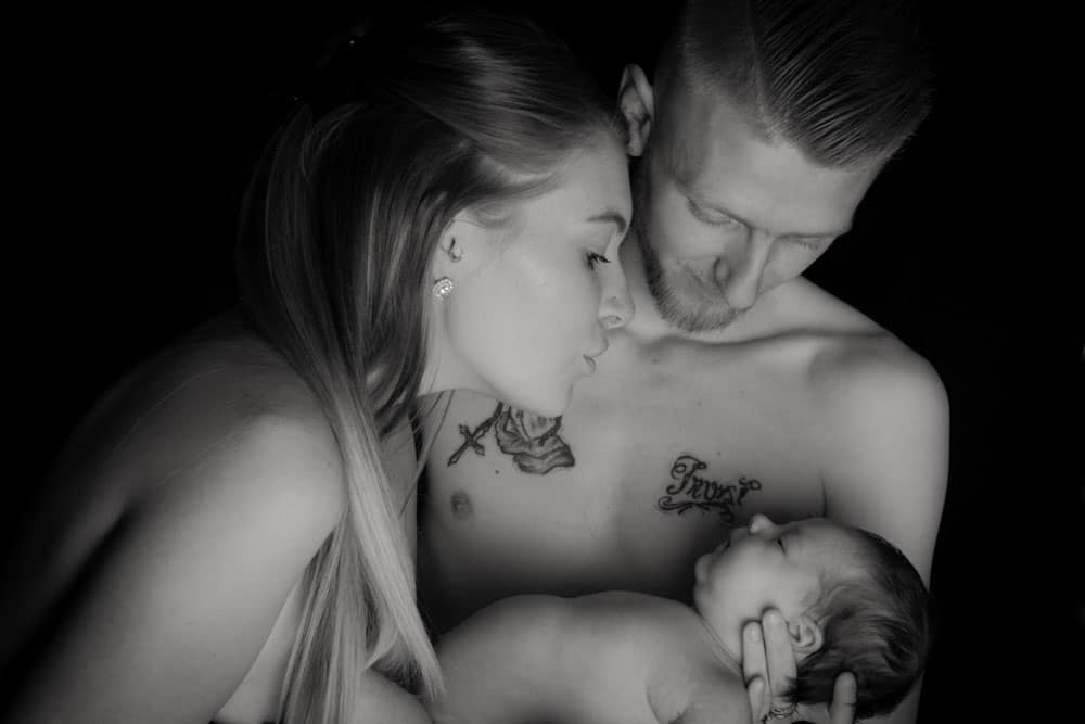newborn baby skin to skin with parents during Birmingham photography studio family portrait