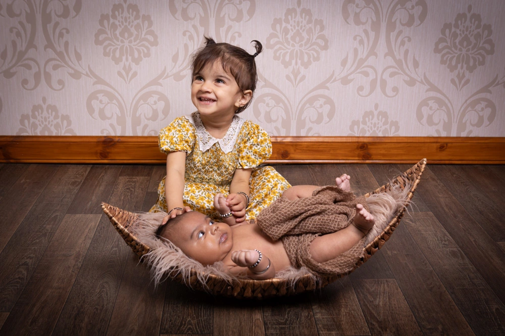 newborn baby with older sibling during Birmingham photography studio family session