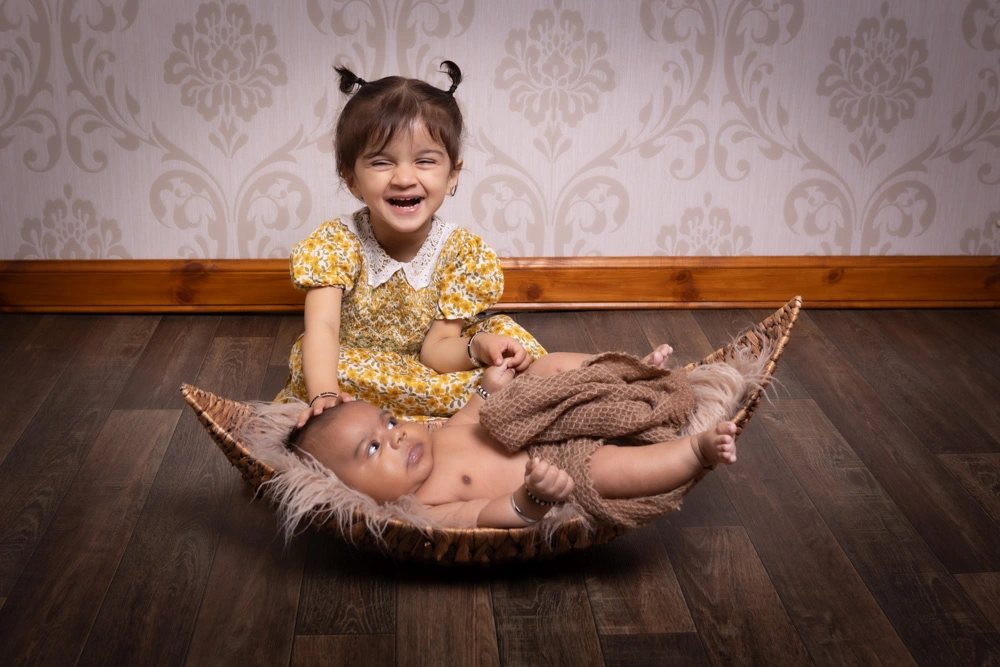 newborn baby with older sibling during Birmingham newborn photography studio session