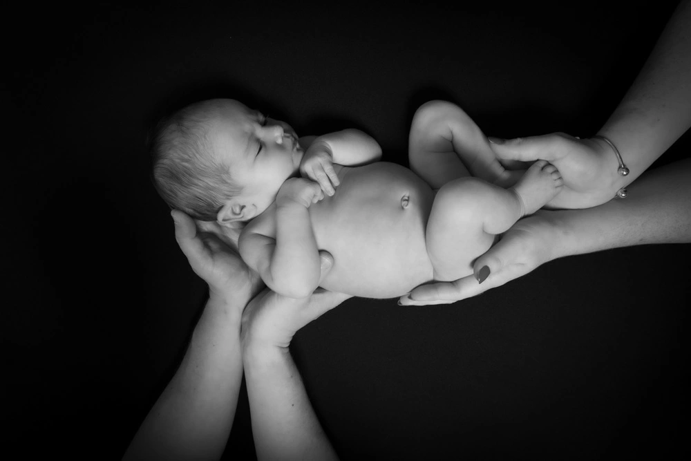 black and white newborn baby portrait in Birmingham photography studio held gently in hands