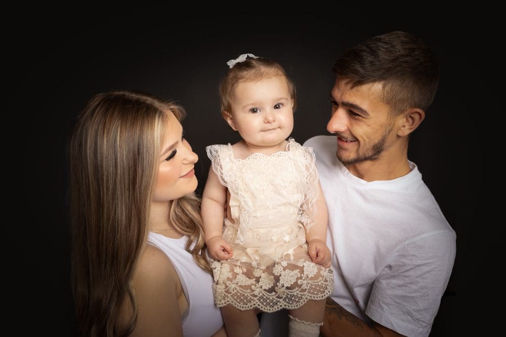 Parents holding their baby daughter during a professional family photoshoot in Birmingham studio