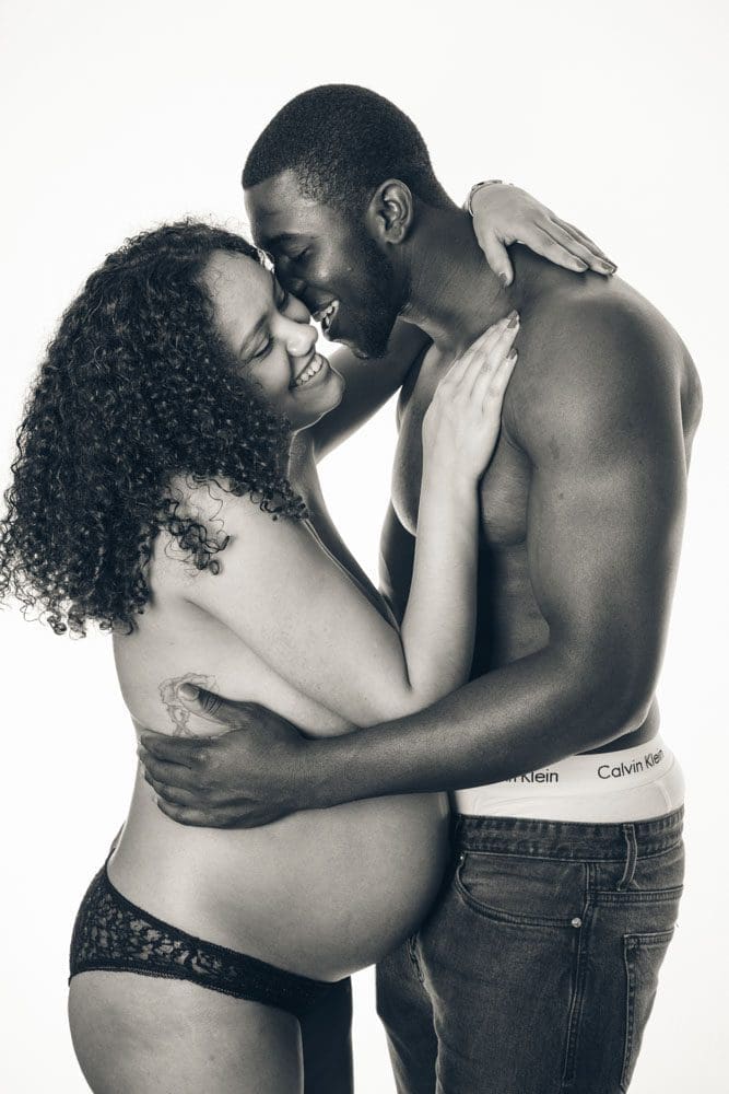 Expectant couple sharing a close, affectionate moment during a maternity photoshoot.
