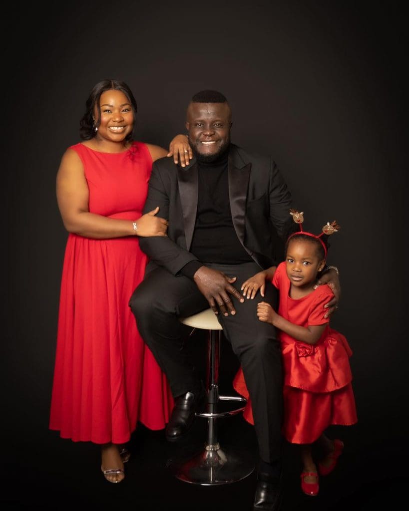family of three studio portrait in Birmingham wearing red outfits