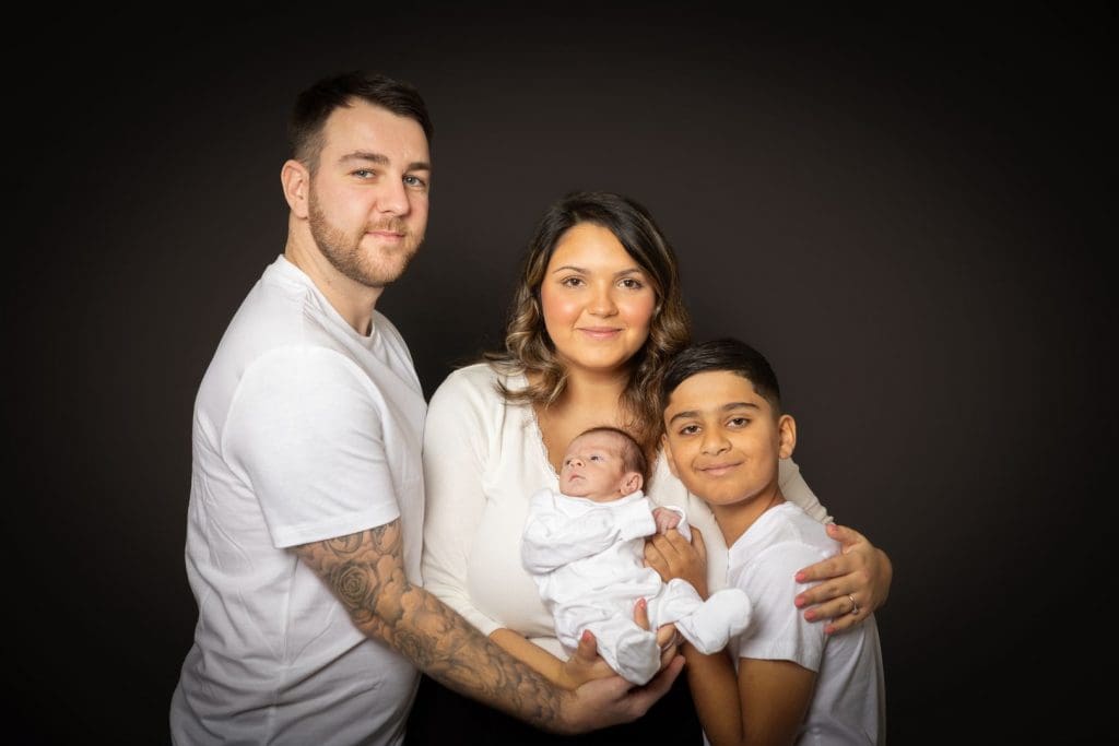 newborn baby with parents and sibling during Birmingham photography studio family session